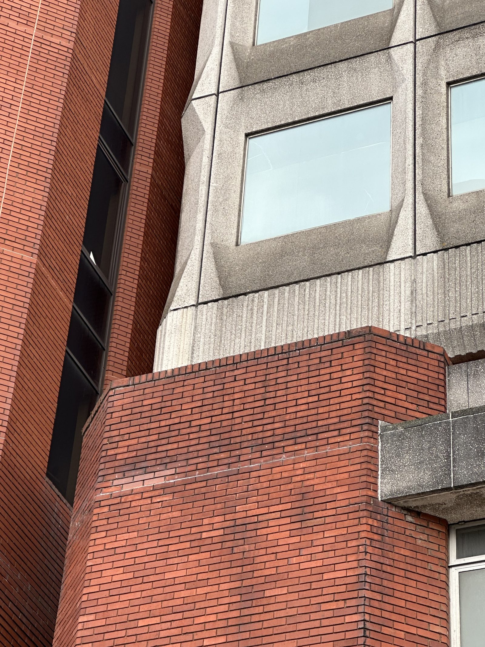 Zbliżenie na styk prefabrykowanego betonu i cegły w Mountbatten House, Chatham, Kent — precyzyjny węzeł materiałowy na elewacji, widoczna różnica tekstury i koloru dwóch materiałów. Fot. Sunolafjagtenben-hur, CC0, Wikimedia Commons