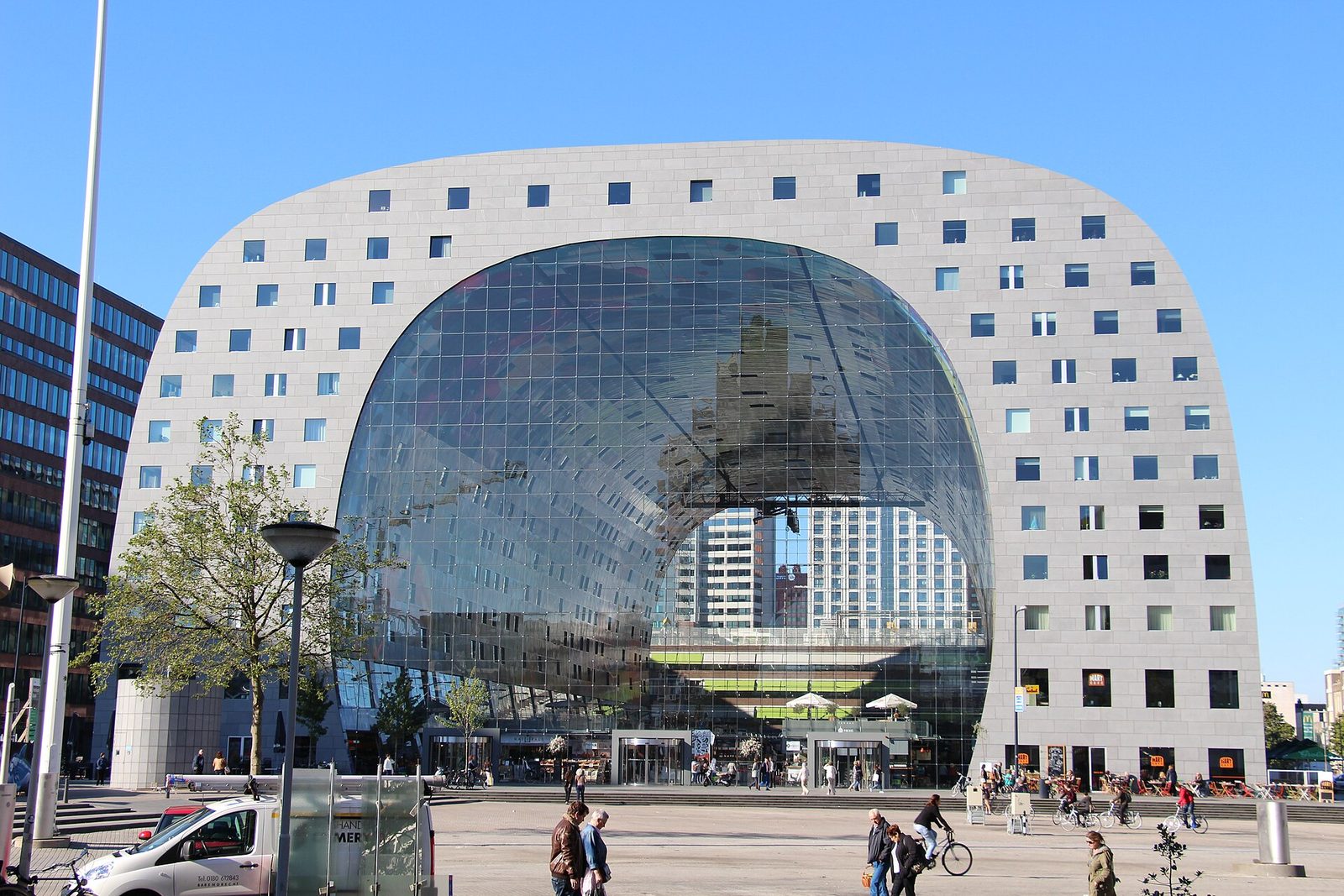 Markthal w Rotterdamie — projekt MVRDV (2014). Charakterystyczna podkowiasta forma z wielką szklaną fasadą; ta sama pracownia zaprojektowała flagowiec Urban Revivo w Pekinie. Fot. Fred Romero, CC BY 2.0, Wikimedia Commons